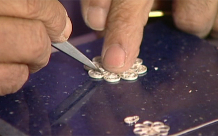 Filling a flower component of a filigree pendant